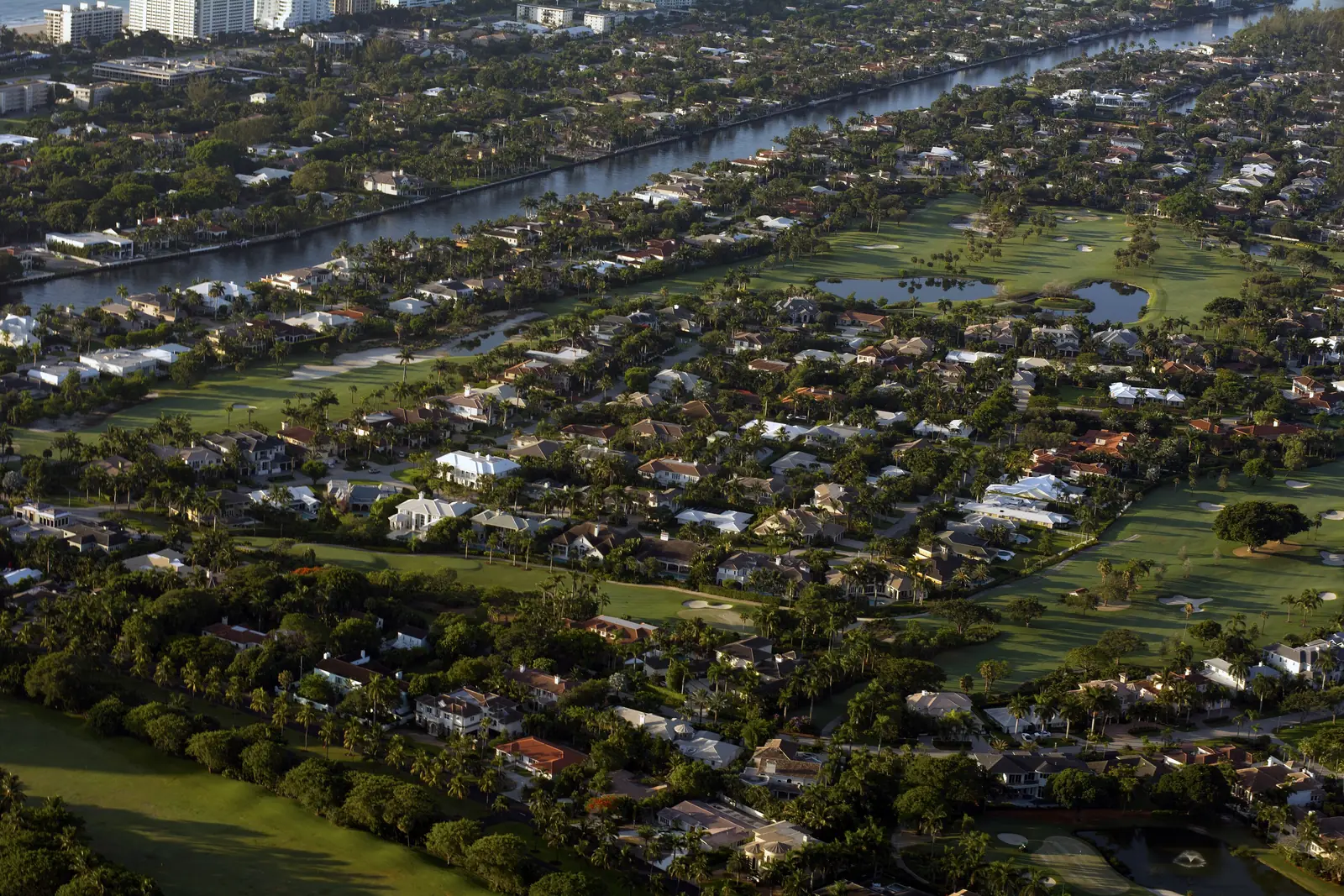 Aerial view of waterfront homes and a golf course at Royal Palm Yacht & Country Club in Boca Raton