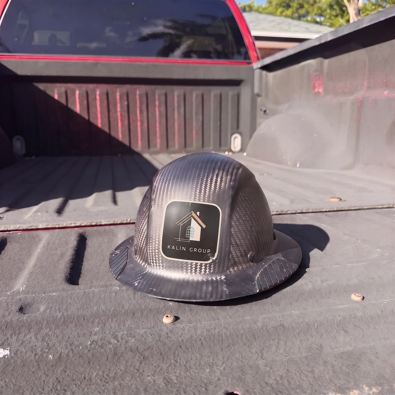 Josh’s carbon-fiber hard hat with a Kalin Group sticker, sitting in the bed of his pickup truck